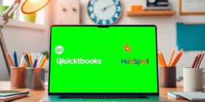 Laptop with QuickBooks and HubSpot on a desk.